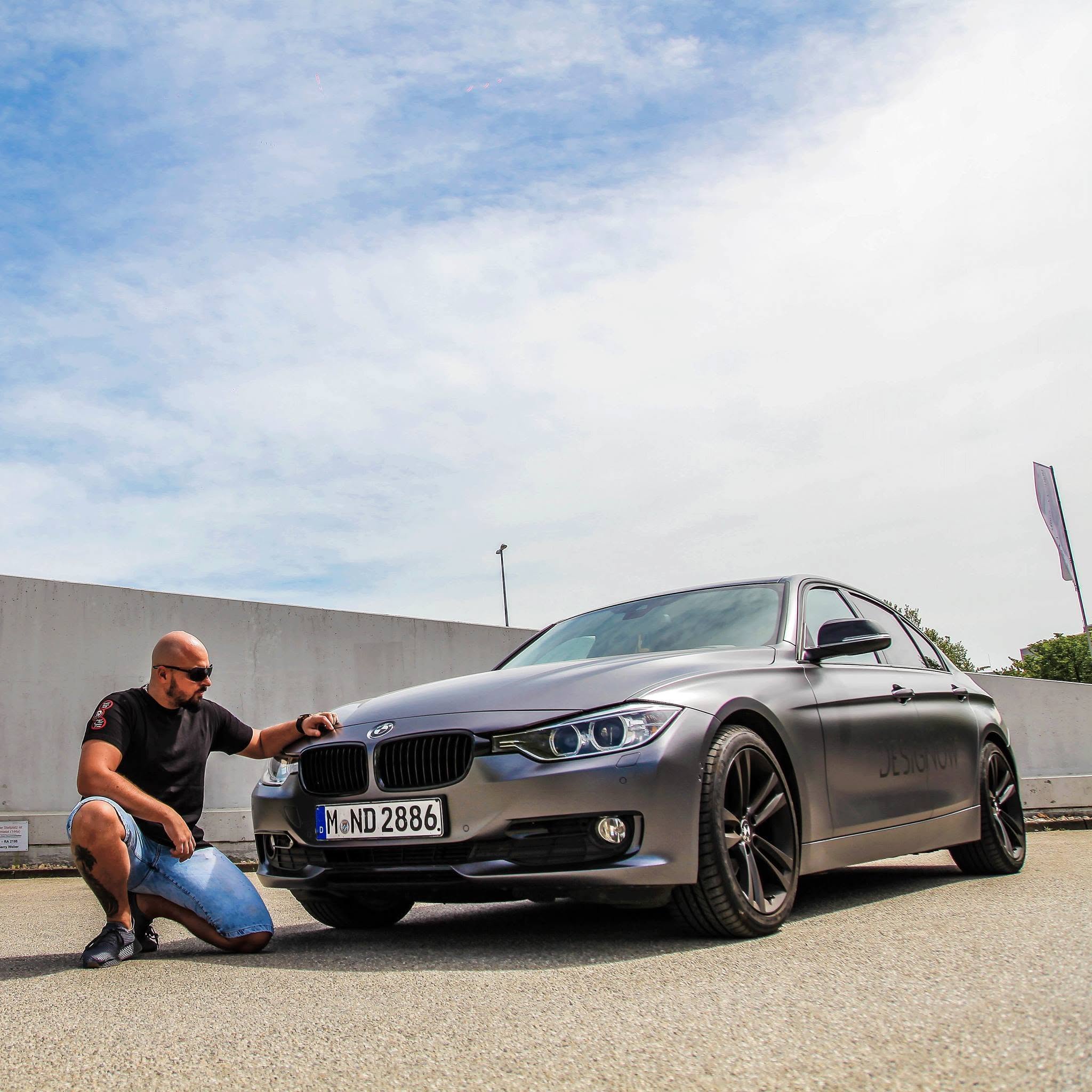 Andy Kürzinger neben einem BMW mit Design-Now-Schriftzug.