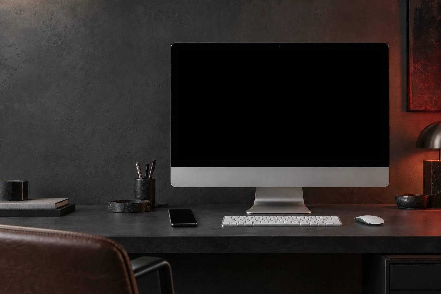 Dunkles Designstudio mit iMac und einem Smartphone auf demselben Schreibtisch